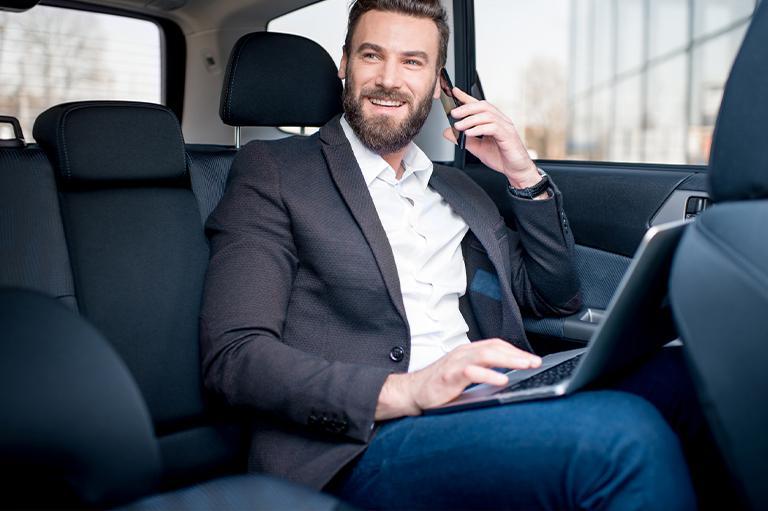 Biznesmen rozmawia przez telefon w taksówce